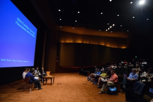 A panel of six people sit in front of a large theater full of documentary filmmakers.