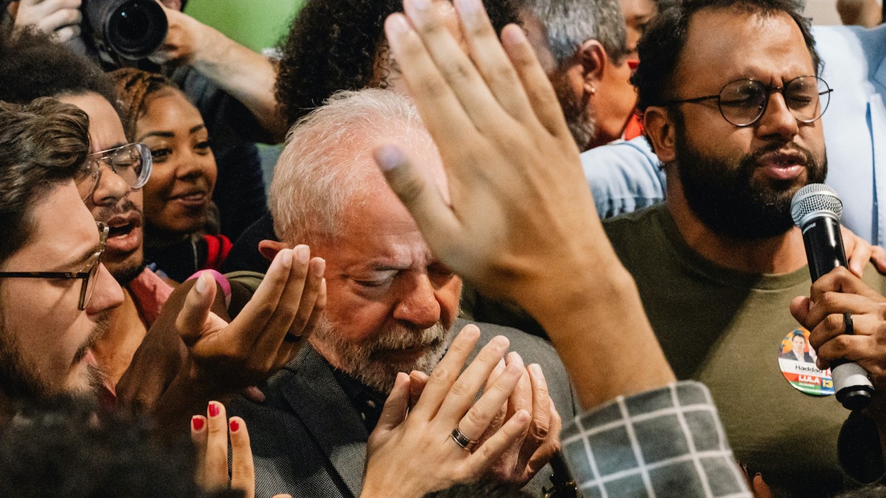 People praying in a group with their hands held out or up.