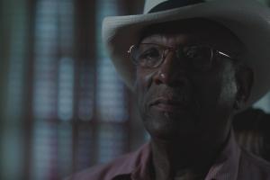 African-American man with a hat staring into the camera