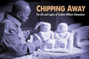 Black and white photograph of William Edmondson carving out a white sculpture.