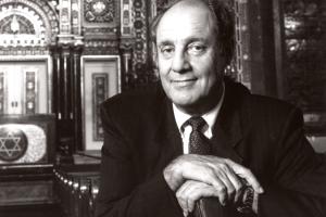 A headshot of Marshall Meyers sitting in a Synagogue 