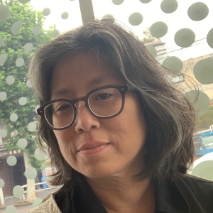 Headshot of Grace Lee, an Asian-American woman with medium length hair, wearing glasses.