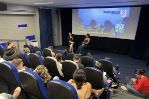 Image of a crowded screening room with blue chairs.