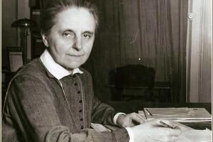 Sister Margaret Slachta is sitting in front of her desk that is covered with letters.
