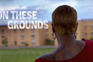 A student looks at her high school building from a distance, title treatment reads ON THESE GROUNDS.