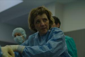 Caucasian women is dressed in blue and white gloves.