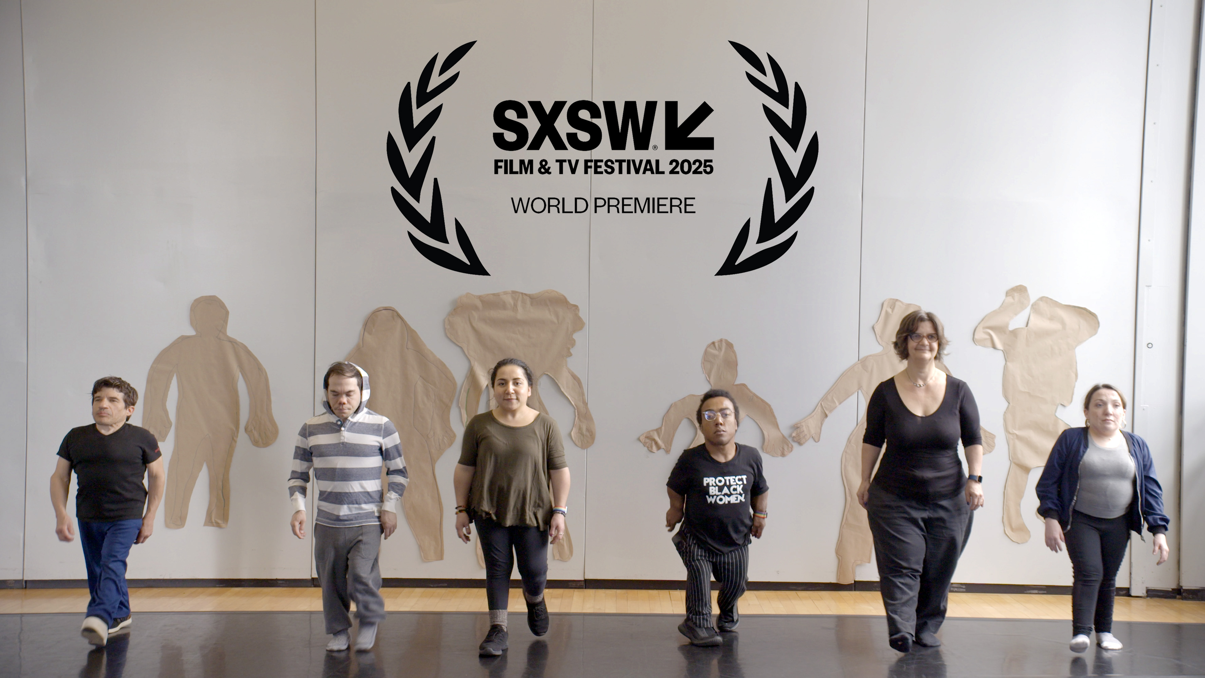 Film still from 'The Tallest Dwarf' via SXSW. Six people are standing sided by side with their shadows cast in tan paper on a white wall in back of them.