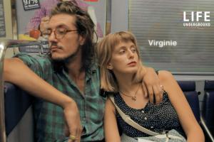 Two Caucasian couple is sitting in a metro subway.