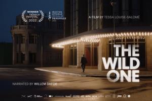 A man walks down a dimly lit street, white text in the foreground says 'The Wild One'