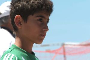 Mark Kabban watches a soccer game next to his coach.
