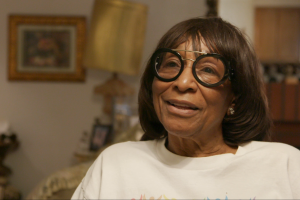 African-American woman, Beulah Mae Mitchell, sits in front of the camera.