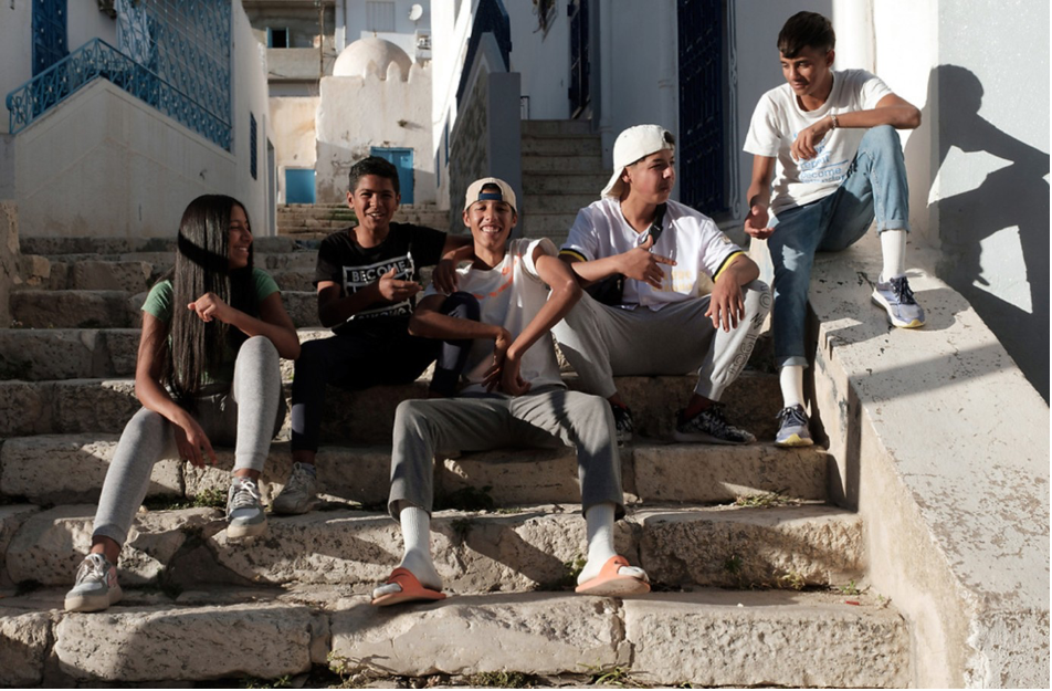 Kids sitting on stone steps outside
