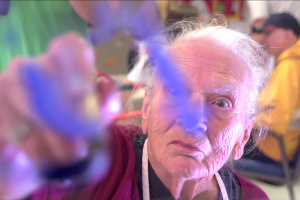 A senior man drawing in front of the camera
