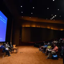 A panel of six people sit in front of a large theater full of documentary filmmakers.