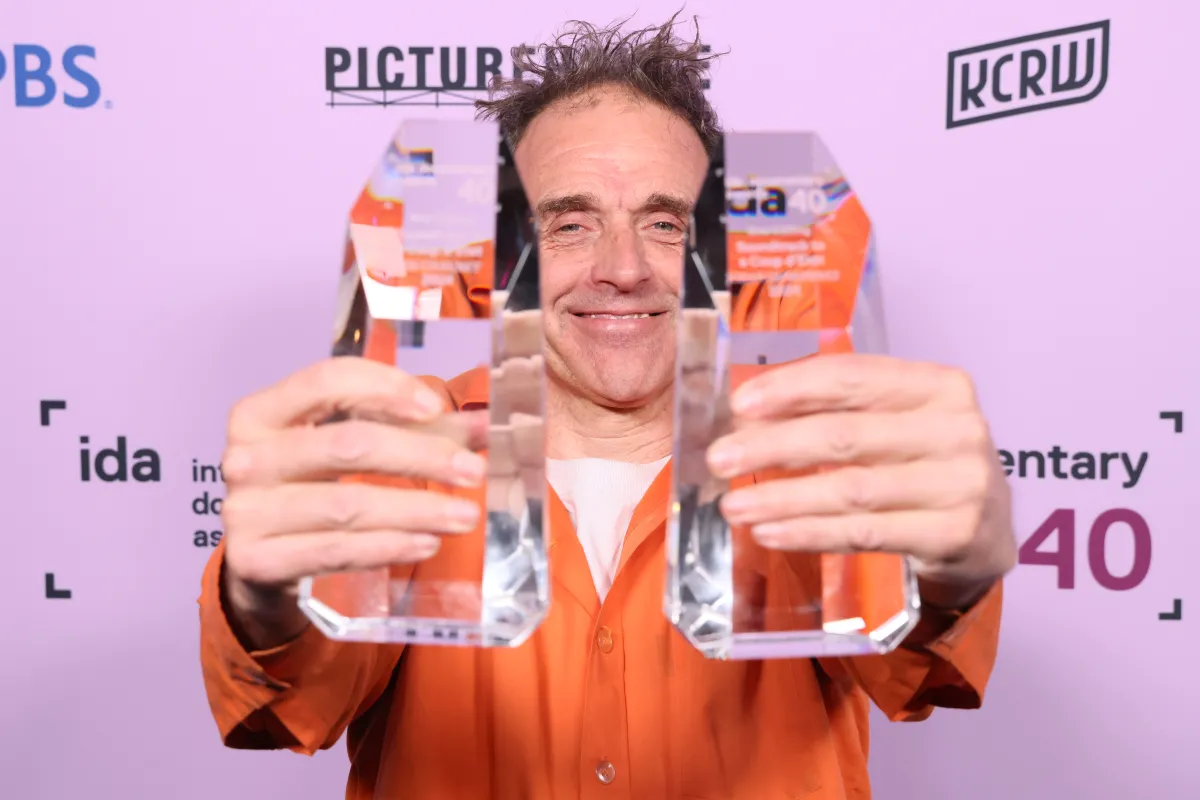 Johan Grimonprez holding his IDA Awards for Soundtrack to a Coup d'Etat in 2024. 