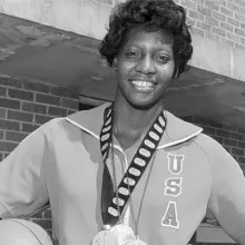Lusia Harris, a Black woman with short black hair, wearing wearing several Olympic medals. A still from Ben Proudfoot's 'The Queen of Basketball'. Courtesy of NY Times Op-Docs