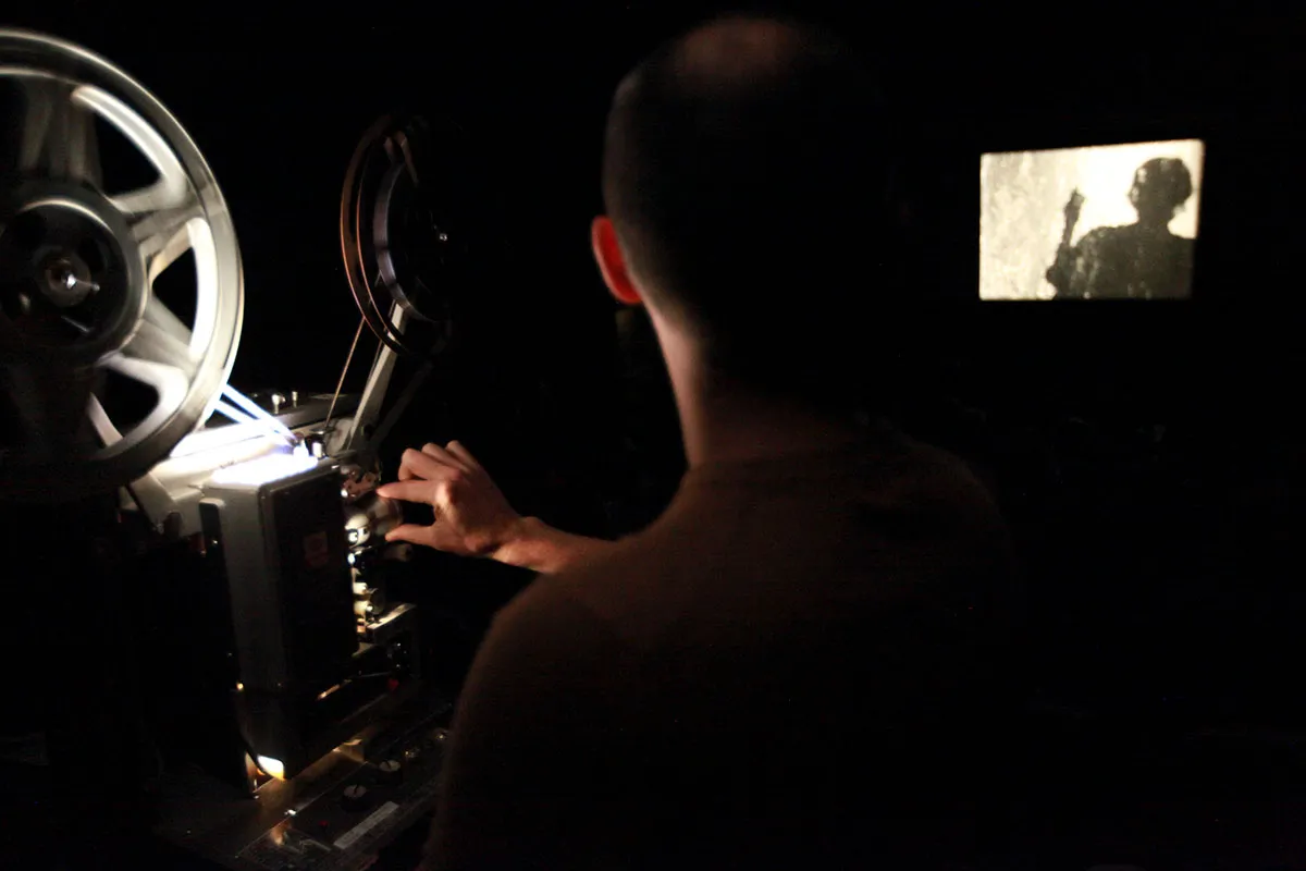 Projectionist Tim White is a white man working a film projector at a Flaherty Film Seminar. Photo by Anne-Katrine Hansen; courtesy of The Flaherty.