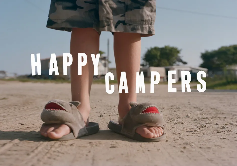 A young boy in shark slippers standing on a dirt road with the title of the film.