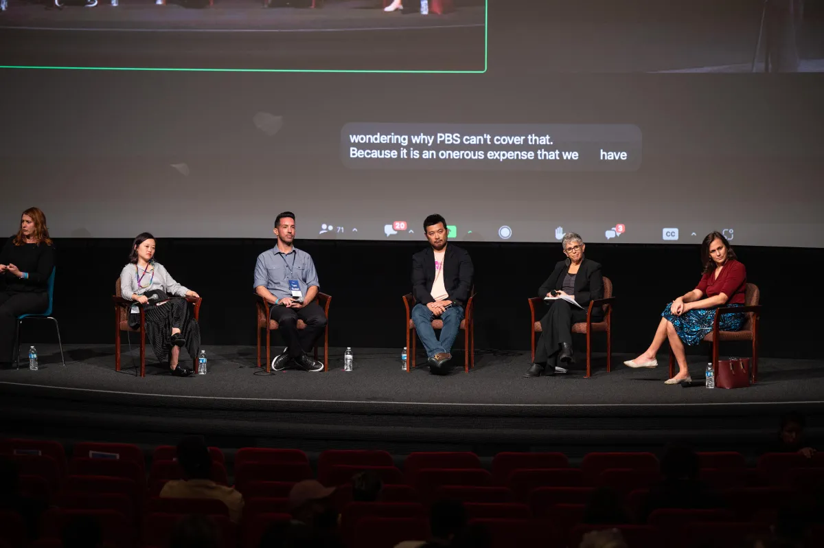 Five people sit on stage.
