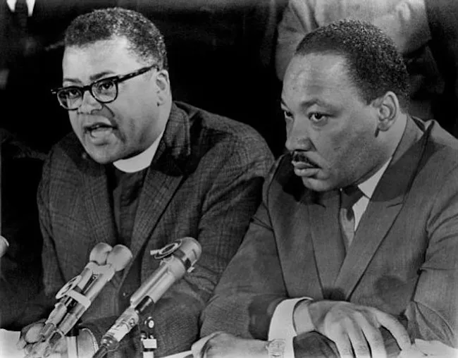 Reverend James Lawson sits and speaks next to Martin Luther King Jr.