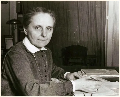 Sister Margaret Slachta is sitting in front of her desk that is covered with letters.