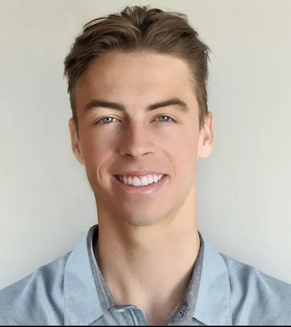 Reed Martin. A man with white skin smiles at the camera. He has short, brown hair, blue eyes and is wearing a blue collared shirt.
